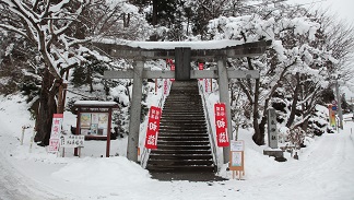 雪が積もった花巻神社へと続く石段の写真