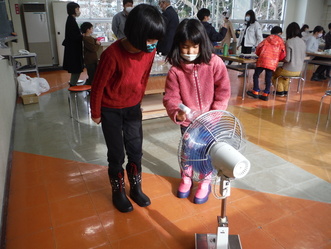 写真2作った風車が回るか確認している様子