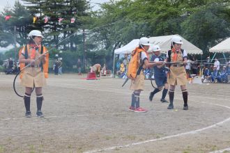 ホースを構える児童