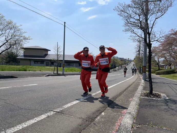 市街地のコースでポーズを取りながら走る消防本部職員