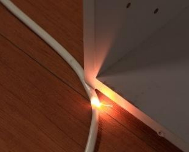 家具の下敷きになった電源コードから出火する画像